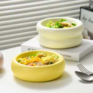 Cute donut-shaped ceramic bowls in yellow and cream for salads, desserts or pet food