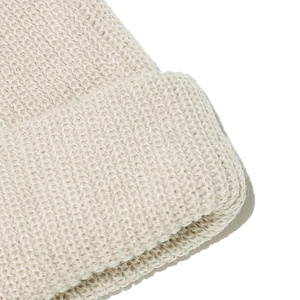 Detailaufnahme der groben Strickstruktur dieser beigen, warmen Wintermütze