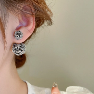 Close-up of vintage geometric silver earrings with textured hollow spherical design