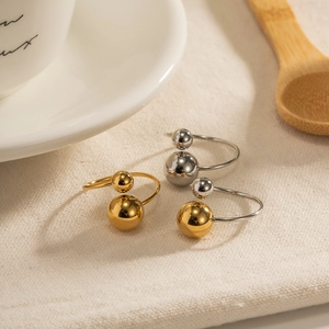 Detailed view of polished gold and silver spherical rings on soft textured fabric background
