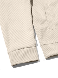Detailed close-up of cream corduroy jacket sleeve cuff and side pocket stitching