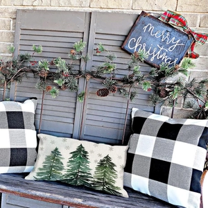 Linen Christmas pillow covers with cedar tree print and plaid pattern on wooden bench