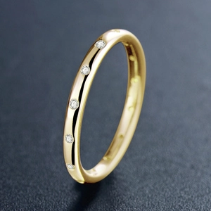 Minimalist gold sterling silver ring with sparkling inset diamonds on grey textured base