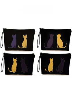 Detail of four black canvas makeup bags with cat prints and matching wrist straps