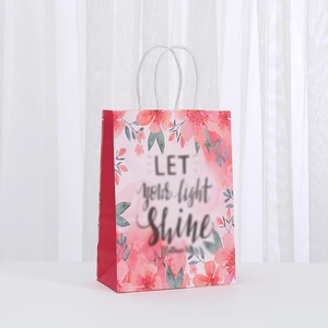 Pink floral kraft gift bag with white woven handles and Matthew 5:16 scripture print
