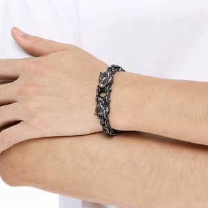 Macro detail of retro silver double wolf head titanium steel bracelet on male wrist