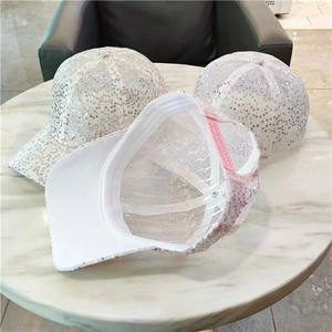 Detail of white sequin baseball cap showing mesh fabric and adjustable pink back strap