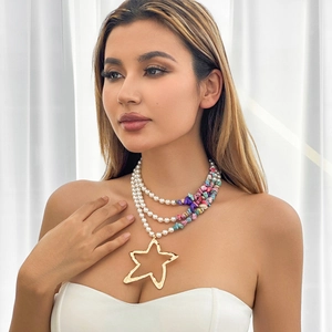 Detail of bohemian multilayer pearl necklace with colorful stones and star pendant