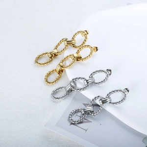 Minimalist gold and silver twist rope chain link earrings on a white stone background