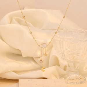 Detailed shot of golden tassel necklace with auspicious cloud and moon charms on silk