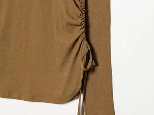 Detailed view of brown ribbed knit top with adjustable side drawstring ruching design