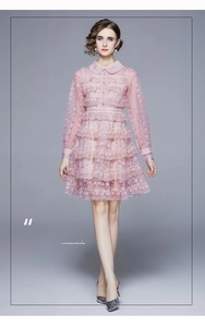 Détail de robe rose en dentelle à volants avec col Claudine perlé et textures élégantes