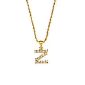 Macro detail of a gold twist chain necklace with a zircon-inlaid letter Z pendant