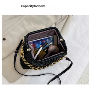 Internal view of black quilted shell bag showing space for tablet and makeup items