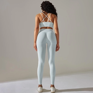 Detail of light blue cross-strap sports bra and seamless high-waist yoga leggings