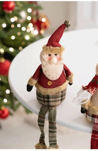 Detail of Christmas Santa plush with knit hat, long legs, and a small copper bell ornament