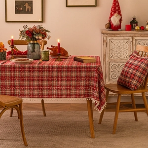 Festive red plaid tablecloth with white pom-pom fringe for Christmas table decor