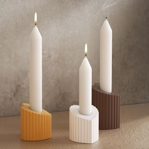 Detailed close-up of ribbed heart-shaped candle holders in three earthy tones