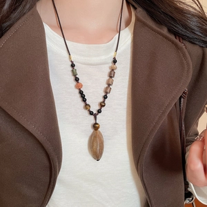 Detailed view of vintage ethnic pendant with natural brown stone and mixed beads