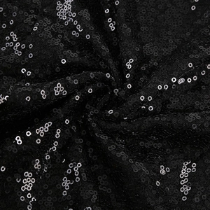 Détail de paillettes noires sur tissu résille pour une robe de soirée étincelante