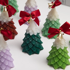 Green and white Christmas tree shaped scented candles with red bows and gold bells