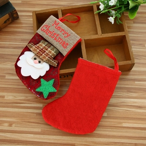 Vintage style red Christmas stockings with Santa Claus applique on a rustic wooden table