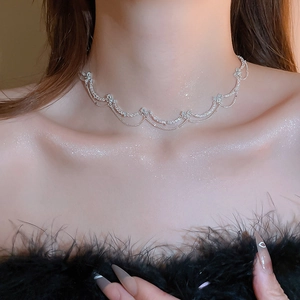 Detailed close-up of a silver butterfly zircon necklace with elegant tassels on a model