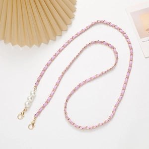 Detail of purple woven leather and gold metal chain strap with elegant pearl accents