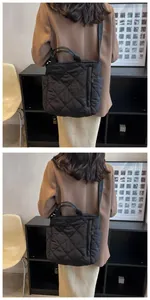 Detail view of black quilted tote bag with padded texture and side pocket for daily use