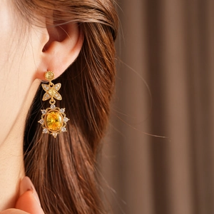 Nahaufnahme des Vintage-Goldohrrings mit großem gelben Edelstein und Zirkonia
