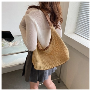 Chic beige mesh woven hobo bag with brown leather strap worn by model in a modern room