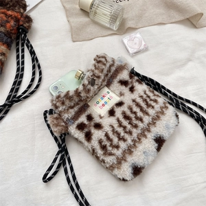 Close-up of plush leopard print crossbody bag with fabric label and shoulder strap