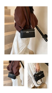 Detail of black lychee leather mini box bag with silver hardware and adjustable strap