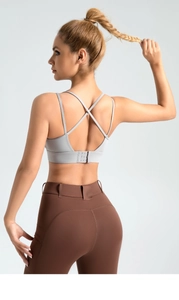 Detail of cross-back straps and multi-clasp closure on a breathable sports bra