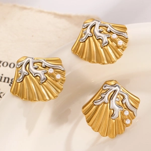 Macro detail of shell shaped earrings in gold and silver finish with small pearls