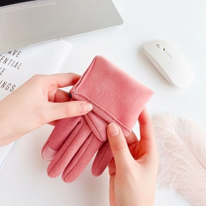 Detailed view of pink touchscreen winter gloves on desk with modern office lifestyle props