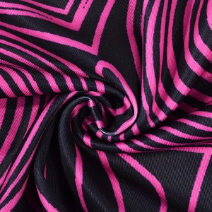 Vue macro de motifs géométriques ondulés rose et noir sur un tissu en maille douce