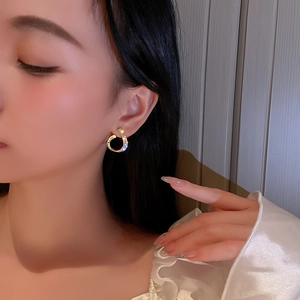 Elegant gold-plated C-shaped drop earrings with sparkling pavé rhinestones on model