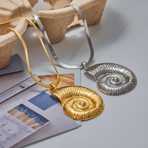 Détails de pendentifs de conque en or et argent sur des chaînes fines de type serpent
