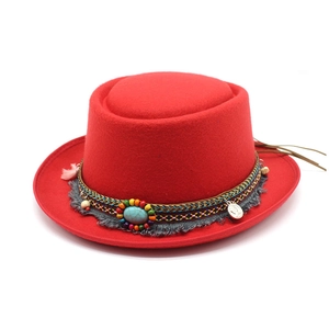 Detail of red wool pork pie hat with bohemian turquoise bead band and fringe tassel