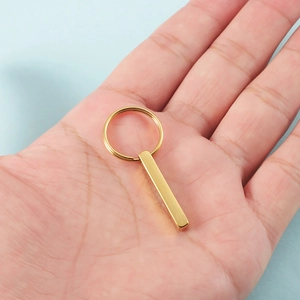 Minimalist gold stainless steel 3D bar keychain with mirror finish held in hand