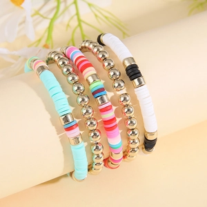 Détail de 5 bracelets bohèmes en argile polymère et perles dorées sur un présentoir