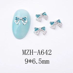 Détail d'un nœud papillon en métal argenté de 9x6,5mm avec strass bleu clair pour ongles