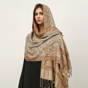 Detail of premium paisley patterns and elegant tassels on a soft cashmere-feel woven shawl