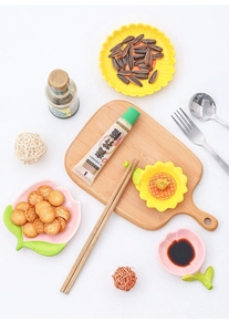 Sunflower and peach shaped ceramic dipping sauce dishes on a wooden tray table setting