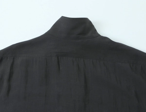 Close-up of black poplin shirt collar with intricate beadwork and refined stitching