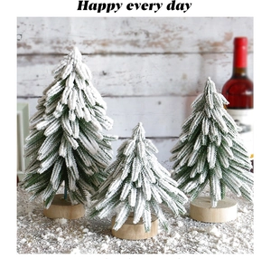 Three miniature snowy Christmas trees with wooden bases set against a cozy holiday background