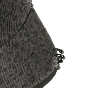 Close-up of distressed grey leopard baseball cap with metal rings and vintage details