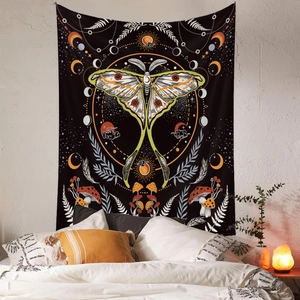 Detail of bohemian butterfly moon moth tapestry hung on wall in a cozy bedroom