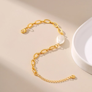 Golden irregular baroque pearl bracelet with textured oval link chain and lobster clasp